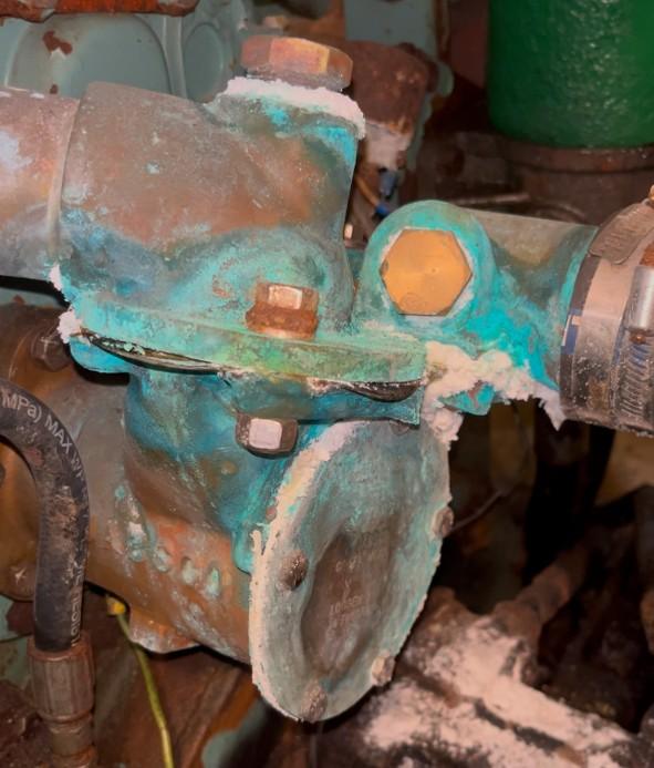 Severely corroded seawater pump housing from Detroit Diesel 8V53T showing salt crystallization and gasket failure