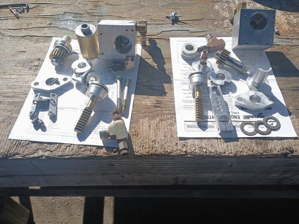 Fully disassembled Hynautic shifter slave components including pistons, seals, springs, bearings, and hardware laid out for rebuild