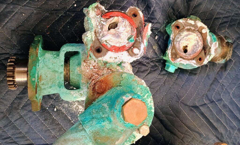 Corroded seawater pump housing clogged with mineral buildup causing poor cooling flow and heat exchanger clogging symptoms diagnosed by 805 Marine Diesel Mechanic