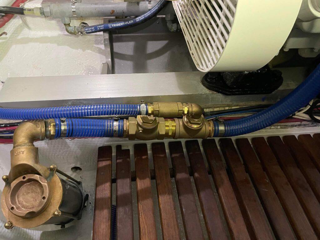 Custom dual marine diesel freshwater flushing system with bronze plumbing and Groco strainers installed in premium yacht engine room