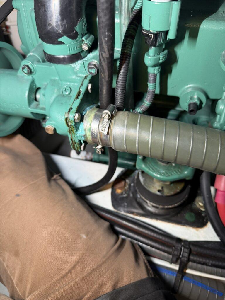 Saltwater pump weep hole leakage on Volvo Penta D4 marine diesel engine indicating seawater pump replacement needed